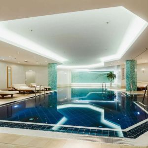 Stunning indoor pool with pool chairs at Hilton Berlin.