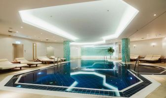 Stunning indoor pool with pool chairs at Hilton Berlin.