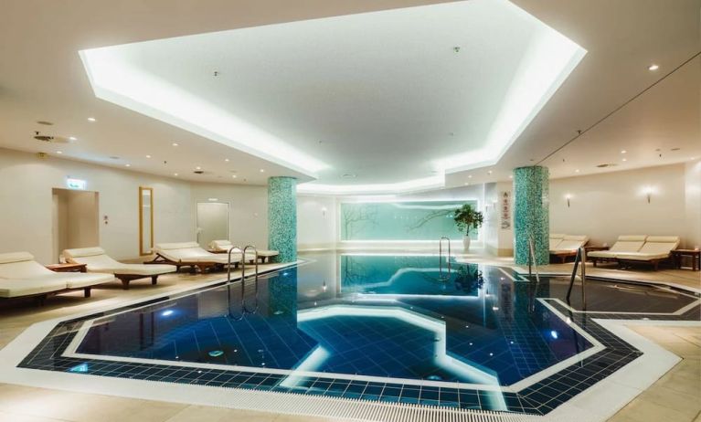 Stunning indoor pool with pool chairs at Hilton Berlin.