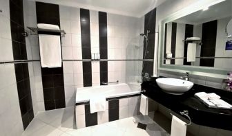 Guest bathroom with shower and bath at Millennium Central Doha.