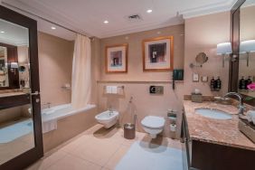 Guest bathroom with shower and bath at Millennium Hotel Doha.