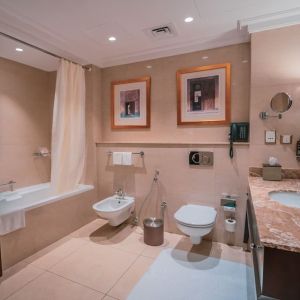 Guest bathroom with shower and bath at Millennium Hotel Doha.