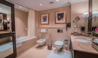 Guest bathroom with shower and bath at Millennium Hotel Doha.