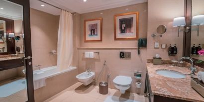 Guest bathroom with shower and bath at Millennium Hotel Doha.