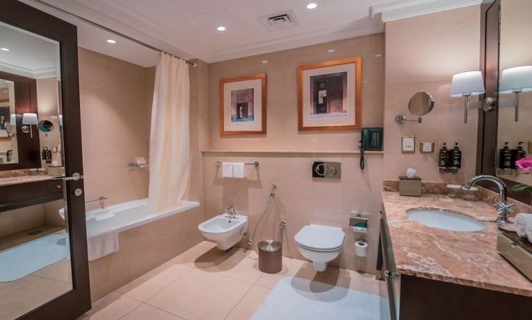 Guest bathroom with shower and bath at Millennium Hotel Doha.