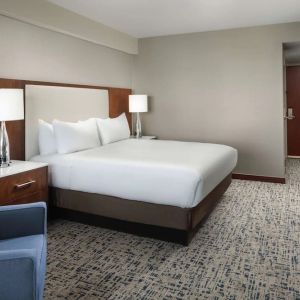 King bed with TV and work desk at Hilton Boston Logan Airport.