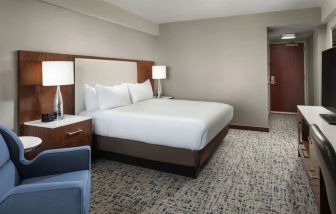 King bed with TV and work desk at Hilton Boston Logan Airport.