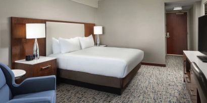 King bed with TV and work desk at Hilton Boston Logan Airport.