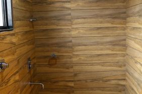 Guest bathroom with shower and towels at Hotel Alka Residency.