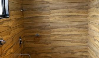 Guest bathroom with shower and towels at Hotel Alka Residency.