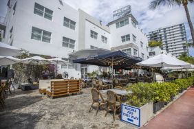 Comfortable outdoor tables and chairs with umbrellas ideal for coworking at Catalina Hotel & Beach Club.