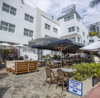 Comfortable outdoor tables and chairs with umbrellas ideal for coworking at Catalina Hotel & Beach Club.