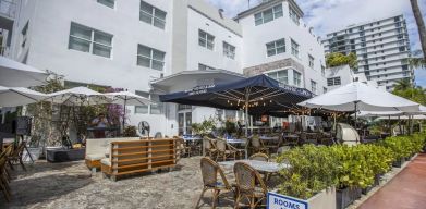 Comfortable outdoor tables and chairs with umbrellas ideal for coworking at Catalina Hotel & Beach Club.