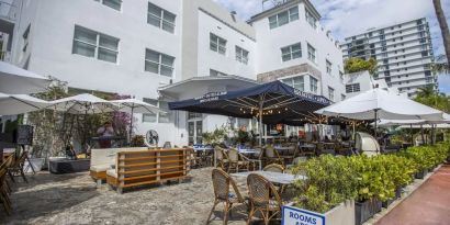 Comfortable outdoor tables and chairs with umbrellas ideal for coworking at Catalina Hotel & Beach Club.