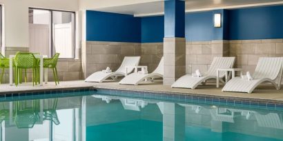 The hotel’s large indoor swimming pool, with surrounding chairs and loungers.