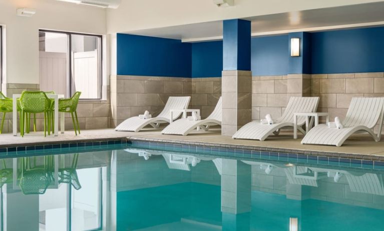 The hotel’s large indoor swimming pool, with surrounding chairs and loungers.