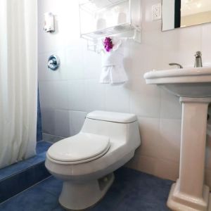 Guest bathroom with shower at Hollywood Beach Suites, A South Beach Group Hotel.