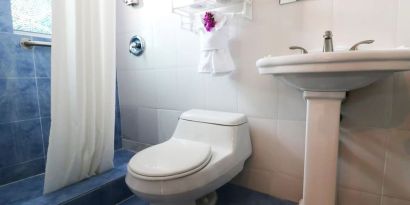 Guest bathroom with shower at Hollywood Beach Suites, A South Beach Group Hotel.