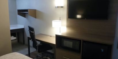 Day room with TV and work desk at Red Roof Plus Bourbonnais.