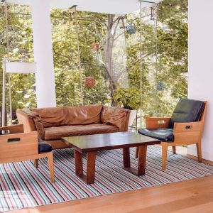 Hotel meeting room with long table and comfy chairs to seat a dozen attendees.