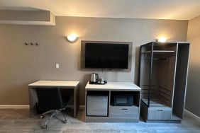 Dayroom with TV, mini-fridge, and work space at Regal Inn & Suites New York.