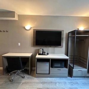 Dayroom with TV, mini-fridge, and work space at Regal Inn & Suites New York.