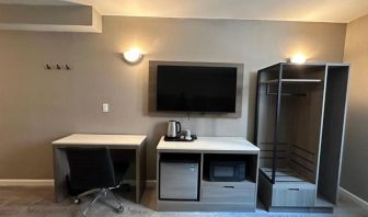 Dayroom with TV, mini-fridge, and work space at Regal Inn & Suites New York.