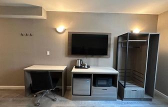 Dayroom with TV, mini-fridge, and work space at Regal Inn & Suites New York.