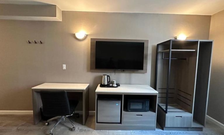 Dayroom with TV, mini-fridge, and work space at Regal Inn & Suites New York.