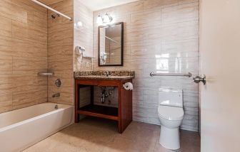 Guest bathroom with shower at Astoria Inn LaGuardia Hotel.