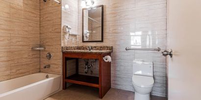 Guest bathroom with shower at Astoria Inn LaGuardia Hotel.