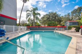 Outdoor pool with seating area at OYO Townhouse Orlando West.