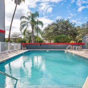 Outdoor pool with seating area at OYO Townhouse Orlando West.