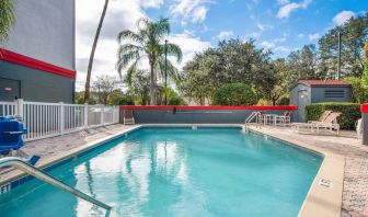 Outdoor pool with seating area at OYO Townhouse Orlando West.