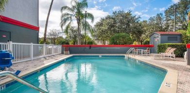 Outdoor pool with seating area at OYO Townhouse Orlando West.