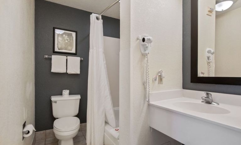 Private bathroom with shower at OYO Townhouse Orlando West.