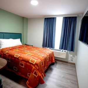 King bed with natural light at Hotel Liberty Inn & Suites.