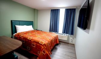 King bed with natural light at Hotel Liberty Inn & Suites.