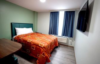 King bed with natural light at Hotel Liberty Inn & Suites.