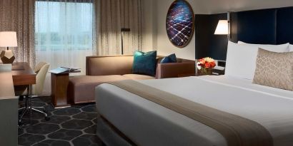 Royal Sonesta Houston Galleria double bed day room, featuring corner sofa and workspace desk and chair.