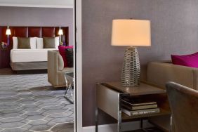 Deluxe king Royal Sonesta Houston Galleria guest room, furnished with coffee table, sofa, and chair.