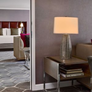 Deluxe king Royal Sonesta Houston Galleria guest room, furnished with coffee table, sofa, and chair.