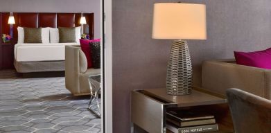 Deluxe king Royal Sonesta Houston Galleria guest room, furnished with coffee table, sofa, and chair.