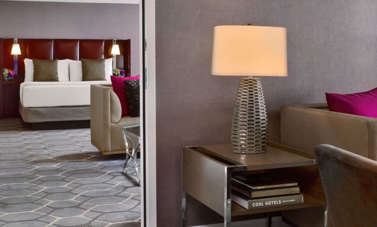 Deluxe king Royal Sonesta Houston Galleria guest room, furnished with coffee table, sofa, and chair.