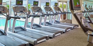 The hotel fitness center has numerous treadmills and other exercise machines, and faces the pool.