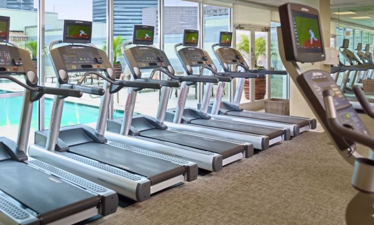 The hotel fitness center has numerous treadmills and other exercise machines, and faces the pool.