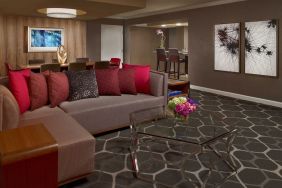 Royal Sonesta Houston Galleria workspace, featuring corner sofa and coffee table, plus long table surrounded by chairs.