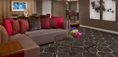 Royal Sonesta Houston Galleria workspace, featuring corner sofa and coffee table, plus long table surrounded by chairs.