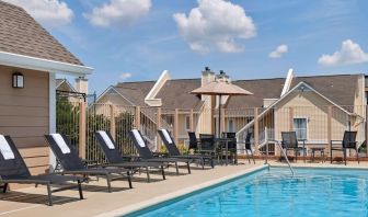 Sonesta ES Suites Tucson’s outdoor pool has a row of sun loungers, plus tables and chairs, by the side.