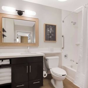 Sonesta Simply Suites Irvine East Foothill guest bathroom, including mirror, lavatory, sink, and bath with a shower.